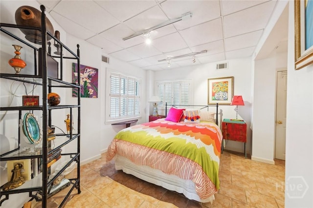 5 Northshore Dr, Tybee Island, GA 31328 - tiled bedroom featuring rail lighting, baseboards, and a drop ceiling