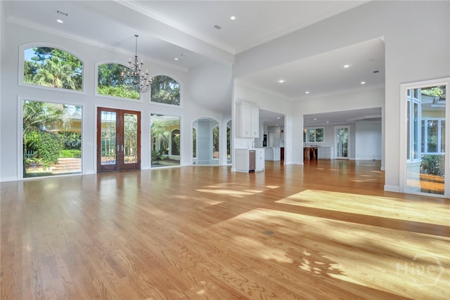 3 Elcy Ln, Savannah, GA 31411 - unfurnished living room with french doors, plenty of natural light, a towering ceiling, crown molding, and a chandelier