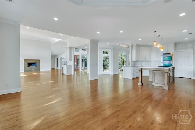3 Elcy Ln, Savannah, GA 31411 - unfurnished living room featuring crown molding, recessed lighting, a premium fireplace, baseboards, and light wood finished floors