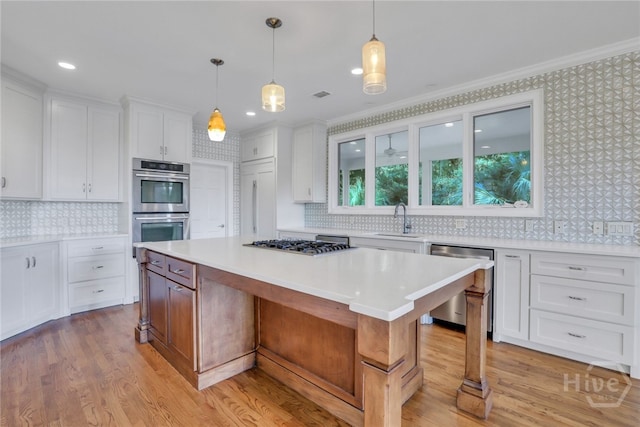 3 Elcy Ln, Savannah, GA 31411 - kitchen featuring appliances with stainless steel finishes, a sink, white cabinets, light countertops, and a kitchen island