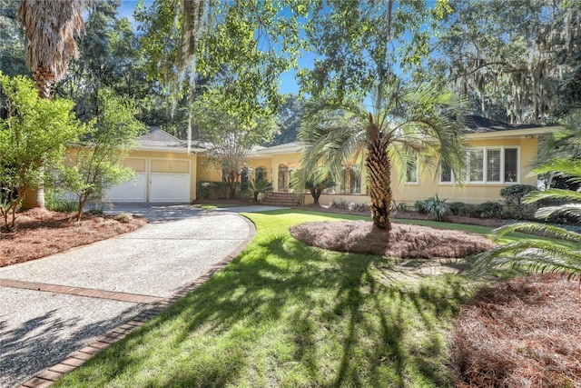 3 Elcy Ln, Savannah, GA 31411 - view of front of property featuring an attached garage, driveway, a front lawn, and stucco siding