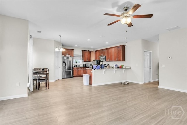 194 Calm Oaks Cir, Savannah, GA 31419 - kitchen with appliances with stainless steel finishes, a peninsula, a kitchen bar, light wood-style floors, and recessed lighting