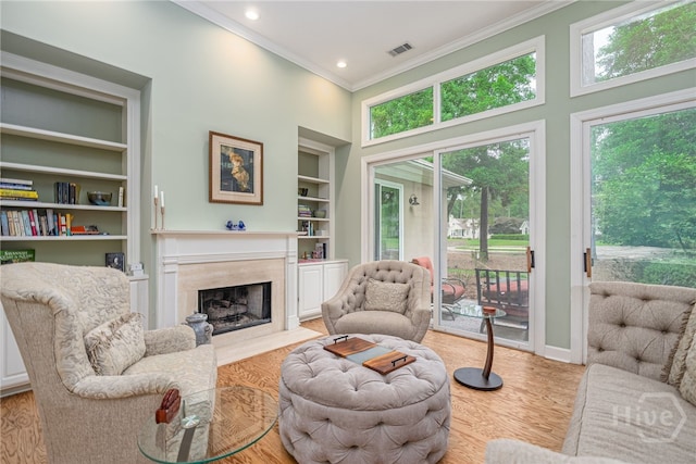 6 Pine Shadow Ct, Savannah, GA 31411 - living area with ornamental molding, a high end fireplace, built in shelves, wood finished floors, and a towering ceiling