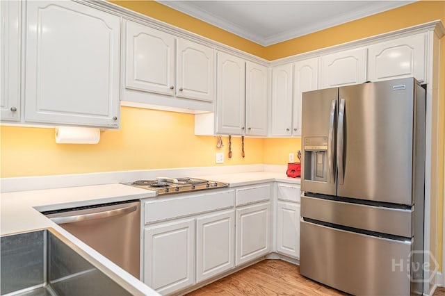 6 Pine Shadow Ct, Savannah, GA 31411 - kitchen featuring appliances with stainless steel finishes, white cabinetry, ornamental molding, light countertops, and light wood finished floors