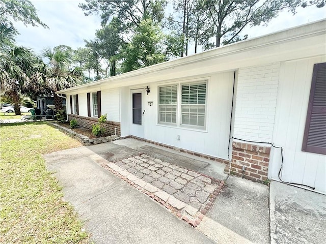 5 Ossabaw Rd, Savannah, GA 31410 - property entrance with brick siding, a yard, and a patio area