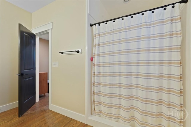 39 Bird Dog Ln, Midway, GA 31320 - full bath with wood finished floors, baseboards, and a shower with curtain