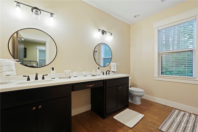 39 Bird Dog Ln, Midway, GA 31320 - bathroom featuring wood finished floors, double vanity, toilet, and baseboards