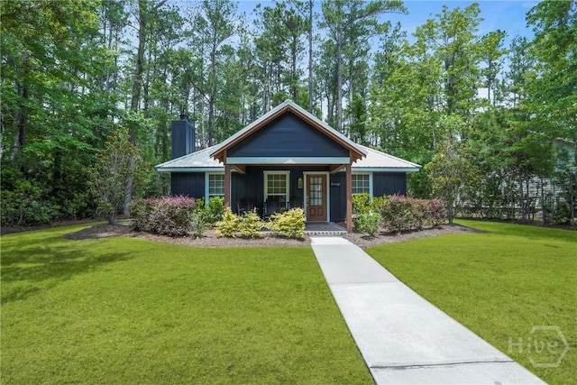 152 Covey Rise Pl, Midway, GA 31320 - view of front of home featuring a front yard, a chimney, and covered porch