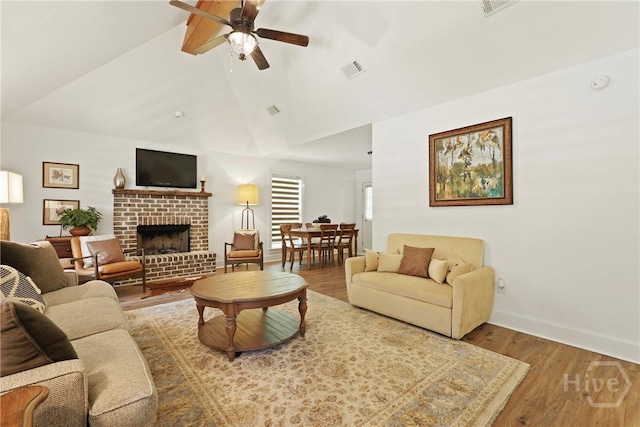 152 Covey Rise Pl, Midway, GA 31320 - living area with ceiling fan, a brick fireplace, wood finished floors, baseboards, and high vaulted ceiling