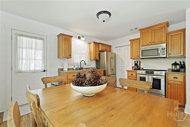 152 Covey Rise Pl, Midway, GA 31320 - kitchen featuring stainless steel appliances, a sink, and light wood-style flooring