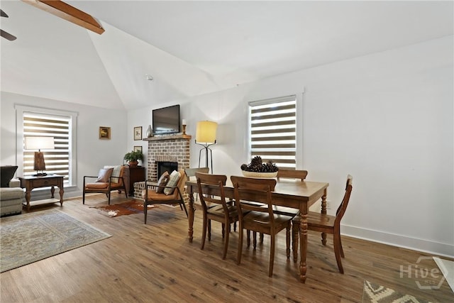 152 Covey Rise Pl, Midway, GA 31320 - dining area with a fireplace, healthy amount of natural light, wood finished floors, ceiling fan, and high vaulted ceiling
