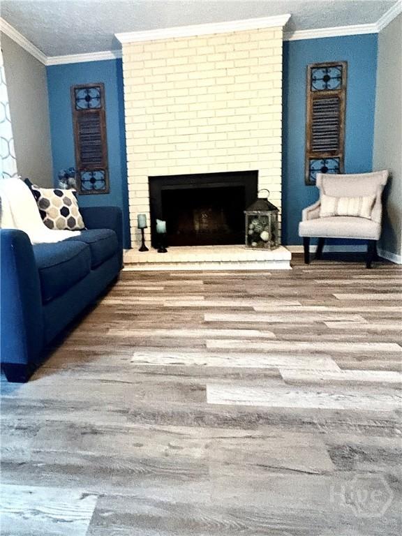 309 Middleton St S, Pooler, GA 31322 - living area with wood finished floors, ornamental molding, a fireplace, a textured ceiling, and baseboards