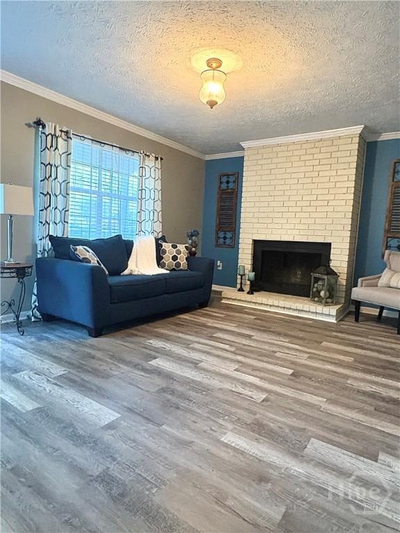 309 Middleton St S, Pooler, GA 31322 - living area with wood finished floors, a textured ceiling, a brick fireplace, and crown molding