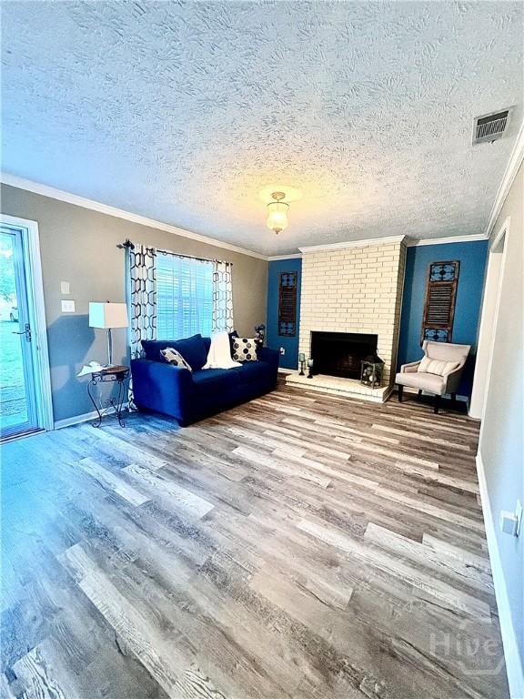 309 Middleton St S, Pooler, GA 31322 - living room with wood finished floors, baseboards, ornamental molding, a textured ceiling, and healthy amount of natural light