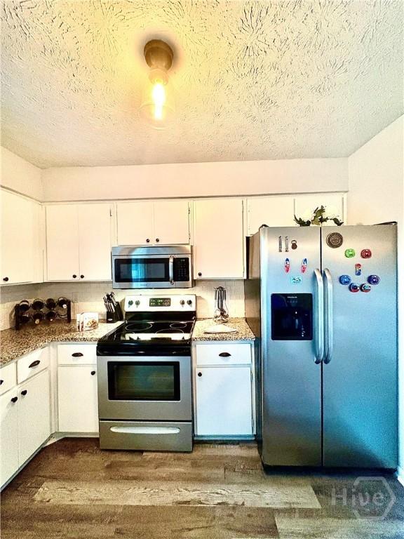 309 Middleton St S, Pooler, GA 31322 - kitchen featuring appliances with stainless steel finishes, a textured ceiling, white cabinets, dark wood-style flooring, and light countertops
