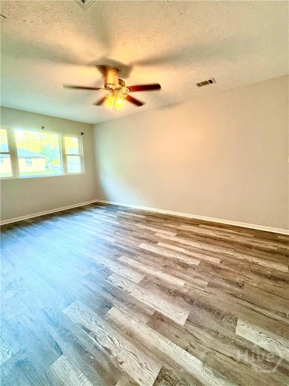 309 Middleton St S, Pooler, GA 31322 - empty room featuring a textured ceiling, wood finished floors, baseboards, and ceiling fan