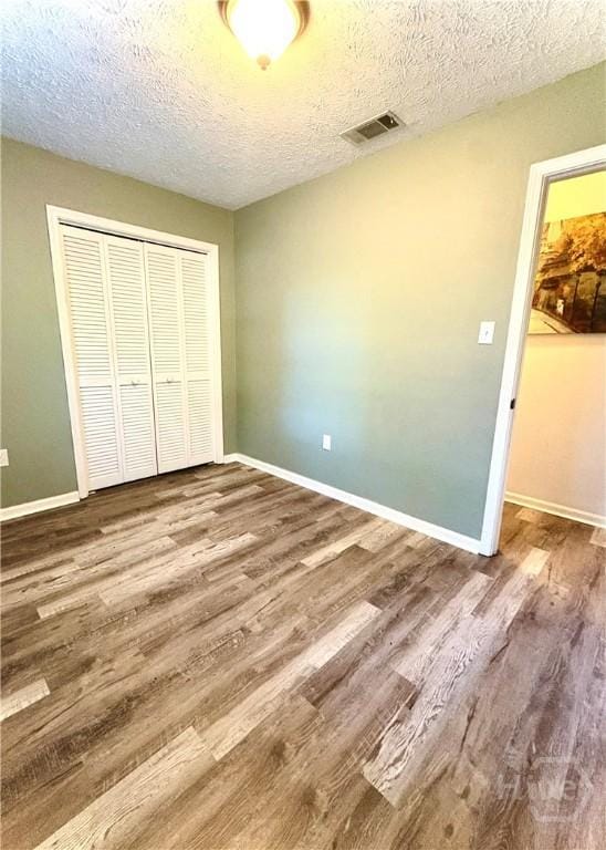309 Middleton St S, Pooler, GA 31322 - unfurnished bedroom featuring a closet, wood finished floors, a textured ceiling, and baseboards