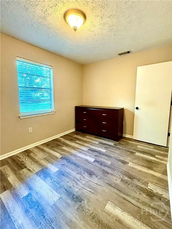 309 Middleton St S, Pooler, GA 31322 - spare room with wood finished floors, a textured ceiling, and baseboards