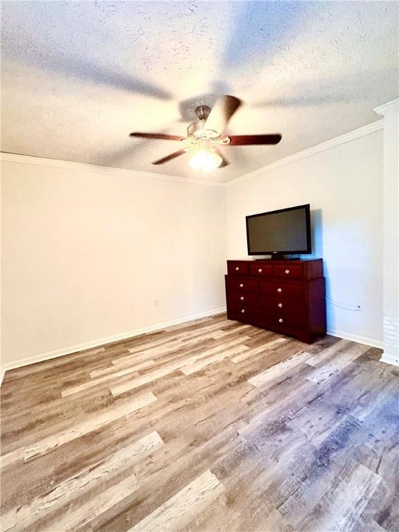 309 Middleton St S, Pooler, GA 31322 - unfurnished bedroom featuring ornamental molding, wood finished floors, a textured ceiling, baseboards, and a ceiling fan