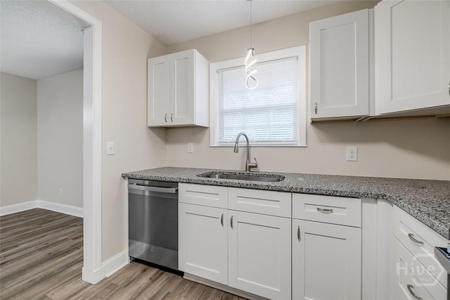405 E 3rd St, Springfield, GA 31329 - kitchen featuring stainless steel dishwasher, a sink, light wood-type flooring, white cabinets, and baseboards