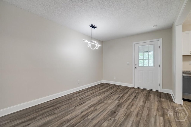 405 E 3rd St, Springfield, GA 31329 - unfurnished dining area featuring dark wood finished floors, a textured ceiling, and baseboards