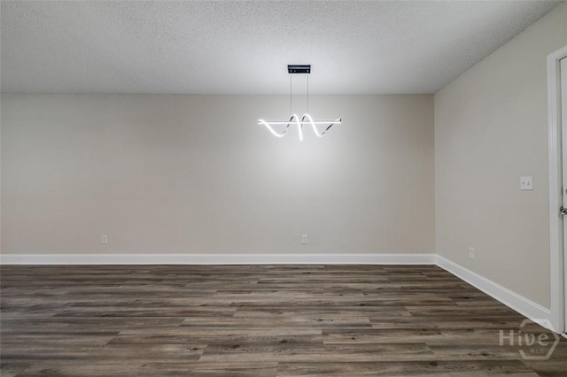 405 E 3rd St, Springfield, GA 31329 - unfurnished dining area featuring dark wood-style flooring, a chandelier, baseboards, and a textured ceiling