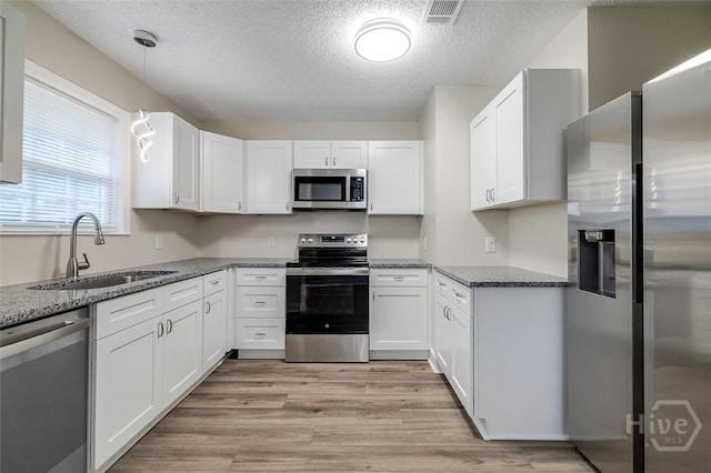 405 E 3rd St, Springfield, GA 31329 - kitchen with stainless steel appliances, a sink, a textured ceiling, white cabinetry, and light wood finished floors