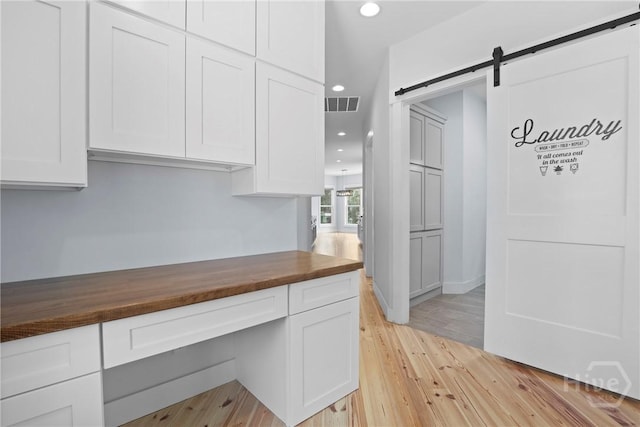 206 Captain Cone Ct, Brooklet, GA 30415 - kitchen featuring wooden counters, white cabinets, recessed lighting, a barn door, and light wood-style floors