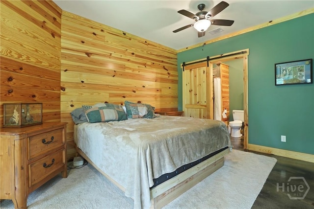 206 Captain Cone Ct, Brooklet, GA 30415 - bedroom with a barn door, wood walls, baseboards, a ceiling fan, and ensuite bath