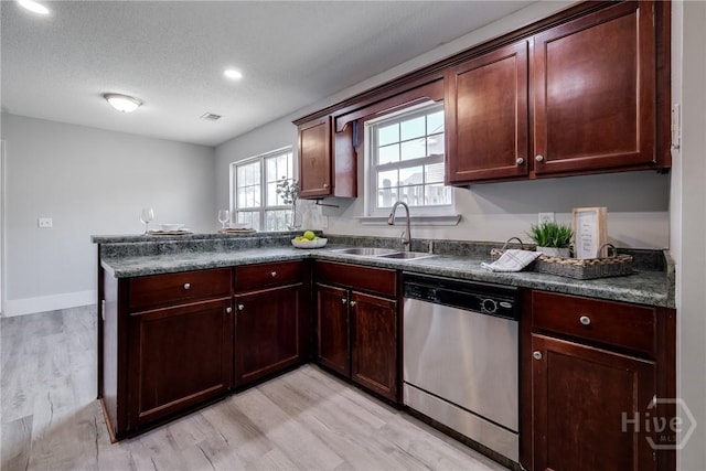 82 Saddlebrush Rd, Ellabell, GA 31308 - kitchen with stainless steel dishwasher, a sink, dark countertops, a peninsula, and light wood finished floors