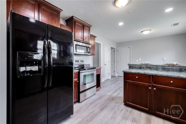 82 Saddlebrush Rd, Ellabell, GA 31308 - kitchen with appliances with stainless steel finishes, light wood-type flooring, a textured ceiling, dark countertops, and recessed lighting