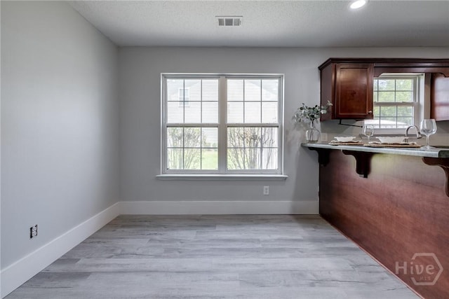 82 Saddlebrush Rd, Ellabell, GA 31308 - kitchen with a kitchen bar, a textured ceiling, light wood-type flooring, baseboards, and recessed lighting