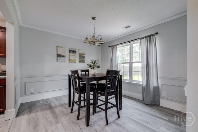 82 Saddlebrush Rd, Ellabell, GA 31308 - dining area featuring ornamental molding, a chandelier, light wood finished floors, and a wainscoted wall