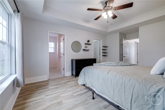 82 Saddlebrush Rd, Ellabell, GA 31308 - bedroom with a tray ceiling, light wood-type flooring, crown molding, baseboards, and ensuite bath