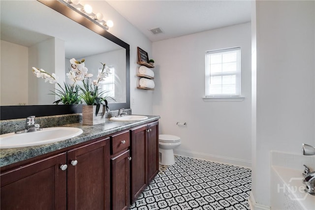 82 Saddlebrush Rd, Ellabell, GA 31308 - bathroom featuring double vanity, toilet, a tub to relax in, and baseboards