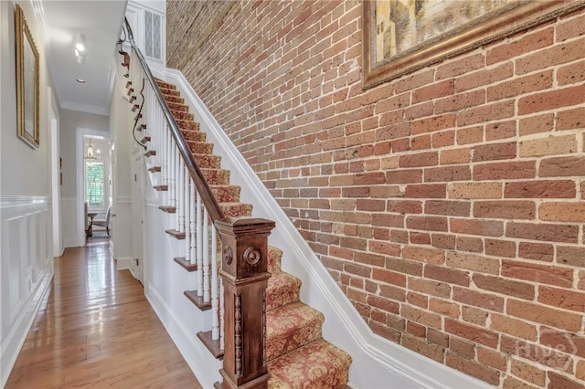 509 E Broughton St, Savannah, GA 31401 - stairway featuring ornamental molding, wood finished floors, and brick wall