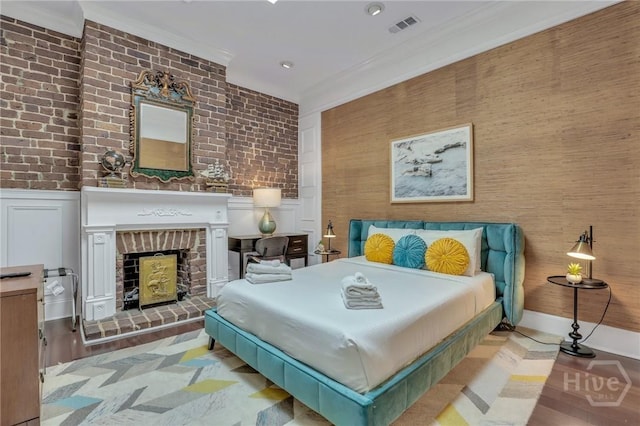 509 E Broughton St, Savannah, GA 31401 - bedroom with wood finished floors, a brick fireplace, crown molding, and wainscoting