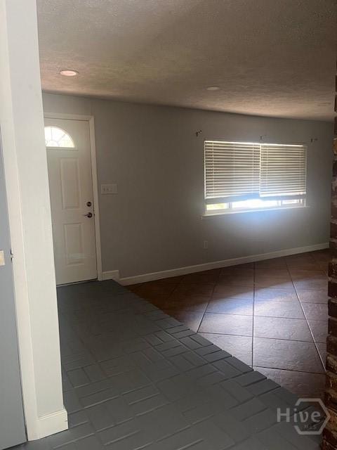 5 Chesterfield Ct, Savannah, GA 31419 - unfurnished room featuring tile patterned floors, a textured ceiling, healthy amount of natural light, and baseboards