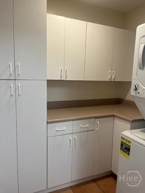 5 Chesterfield Ct, Savannah, GA 31419 - kitchen featuring stacked washer / dryer, white cabinetry, light countertops, and light tile patterned floors