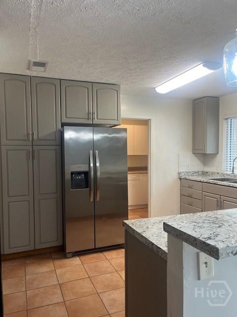 5 Chesterfield Ct, Savannah, GA 31419 - kitchen with stainless steel fridge with ice dispenser, gray cabinetry, a sink, a textured ceiling, and light tile patterned floors