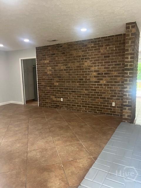 5 Chesterfield Ct, Savannah, GA 31419 - tiled empty room with brick wall, recessed lighting, baseboards, and a textured ceiling