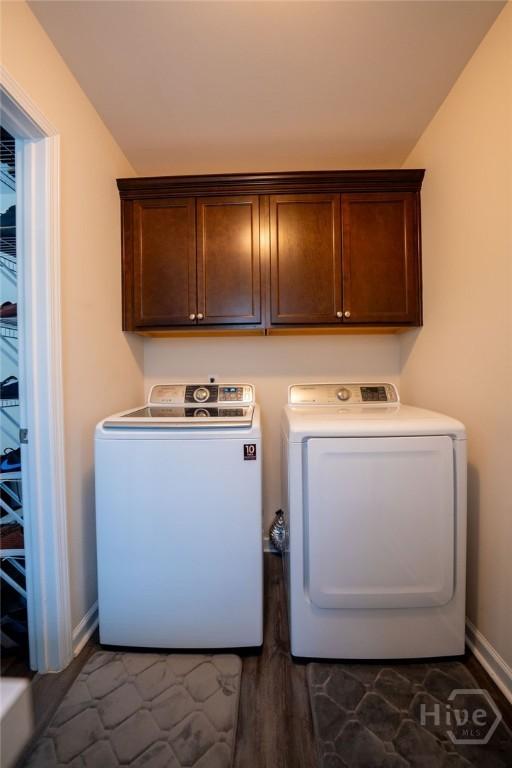 66 Tarbert Cut Cut, Richmond Hill, GA 31324 - washroom with washing machine and clothes dryer, cabinet space, baseboards, and dark wood-type flooring