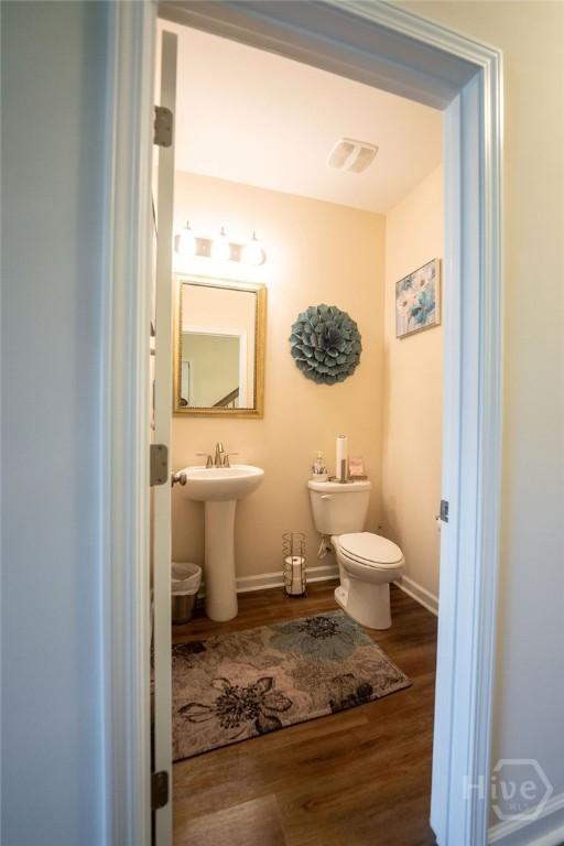 66 Tarbert Cut Cut, Richmond Hill, GA 31324 - half bath with wood finished floors, toilet, and baseboards