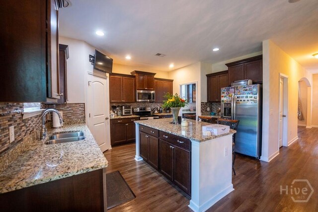 66 Tarbert Cut Cut, Richmond Hill, GA 31324 - kitchen featuring a sink, stainless steel appliances, tasteful backsplash, a center island, and light stone countertops