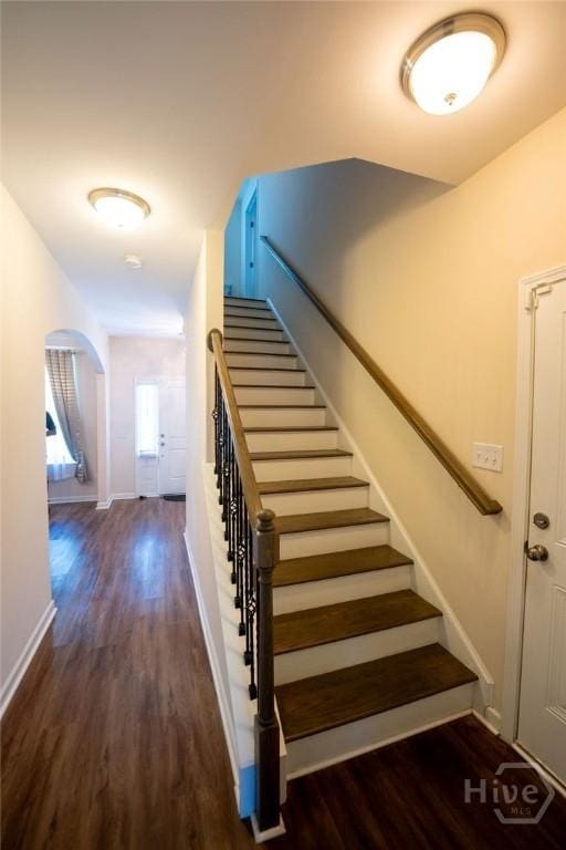 66 Tarbert Cut Cut, Richmond Hill, GA 31324 - staircase featuring wood finished floors, arched walkways, and baseboards