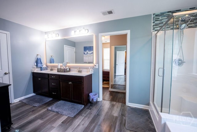 66 Tarbert Cut Cut, Richmond Hill, GA 31324 - bathroom featuring wood finished floors, double vanity, a shower stall, and baseboards