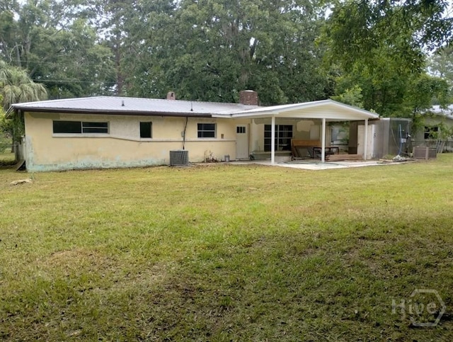 107 Lyons Rd, Pooler, GA 31322 - rear view of property with a yard, a patio area, a chimney, metal roof, and stucco siding