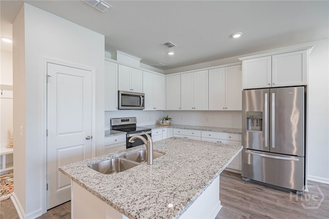 147 Congo Ct, Pooler, GA 31322 - kitchen with stainless steel appliances, a sink, wood finished floors, white cabinetry, and recessed lighting