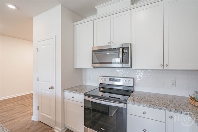 147 Congo Ct, Pooler, GA 31322 - kitchen with stainless steel appliances, decorative backsplash, light wood-style floors, baseboards, and light stone counters