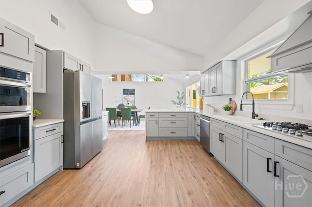 4750 Sylvan Dr, Savannah, GA 31405 - kitchen featuring stainless steel appliances, gray cabinetry, a sink, light countertops, and high vaulted ceiling